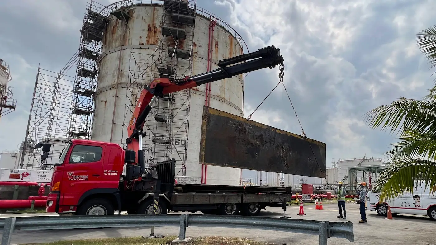 Lorry crane lifting a sheet of metal